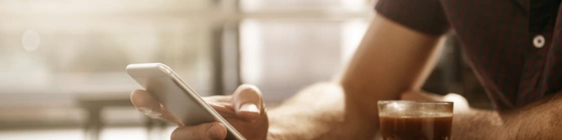 Homme avec mobile et caffee