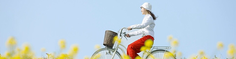 Une jeune femme fait une balade à vélo dans un champ en été