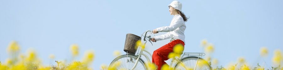 Une jeune femme fait une balade à vélo dans un champ en été