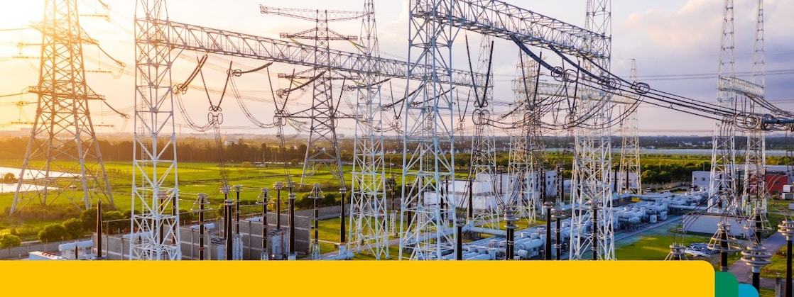 Poste électrique avec lignes de transmission haute tension interconnectées et équipements au coucher du soleil.