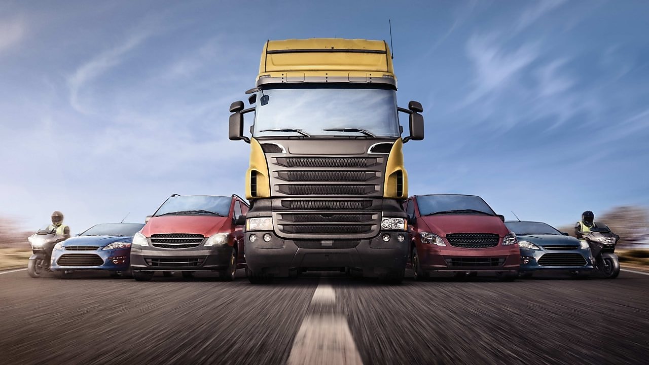 Voitures et camions en ligne sur la route