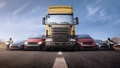 Voitures et camions en ligne sur la route