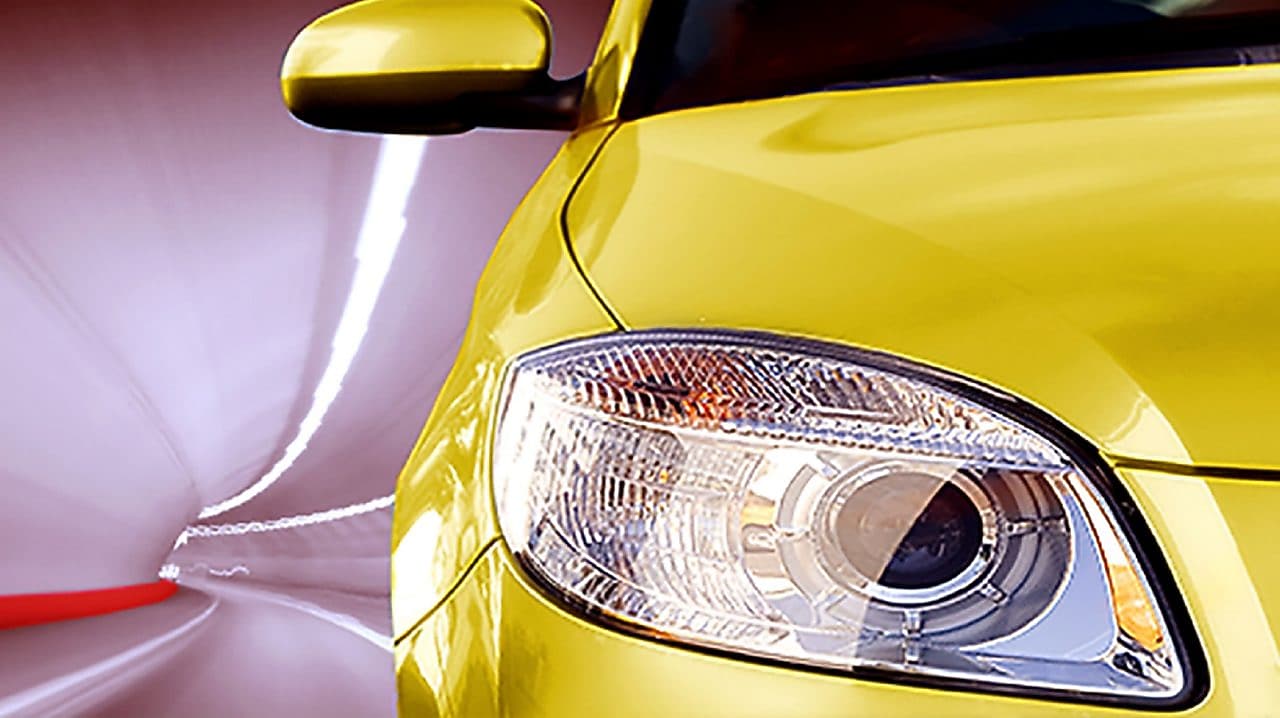 L'avant d'une voiture jaune dans un tunnel, feu avant droit et rétroviseur extérieur