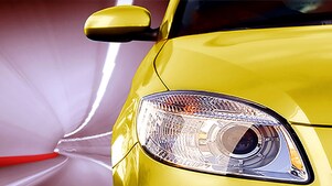 L'avant d'une voiture jaune dans un tunnel, feu avant droit et rétroviseur extérieur