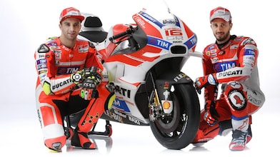 Deux pilotes Ducati 2016 assis à côté d'une moto Ducati