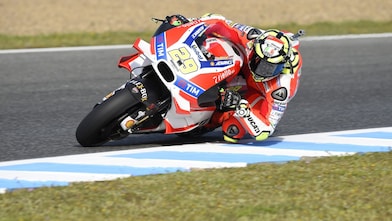 Un pilote sur une moto de course Ducati dans un virage en épingle