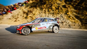 Une voiture de rallye en dérapage sur une route du championnat du monde des rallyes