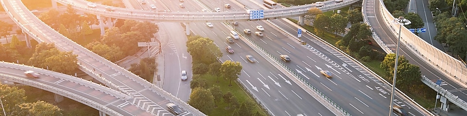 Des voitures circulant sur une infrastructure d’autoroute complexe, avec des ponts et des tunnels