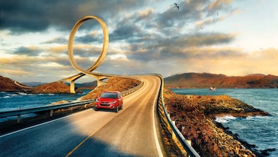 Rode auto rijdt op een weg naast de rivier