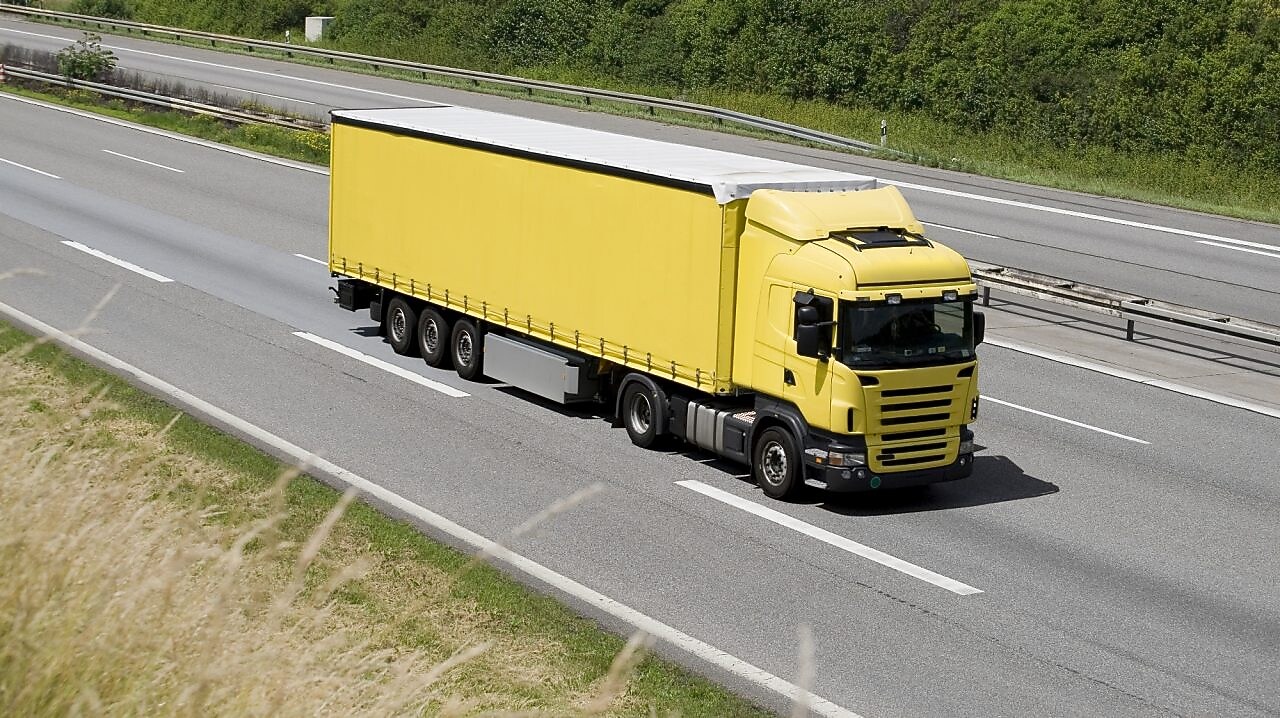 Blue sky over yellow truck on a highway