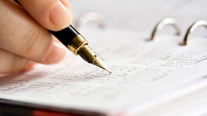 A man doing calculations on a calculator with printed charts on the desk