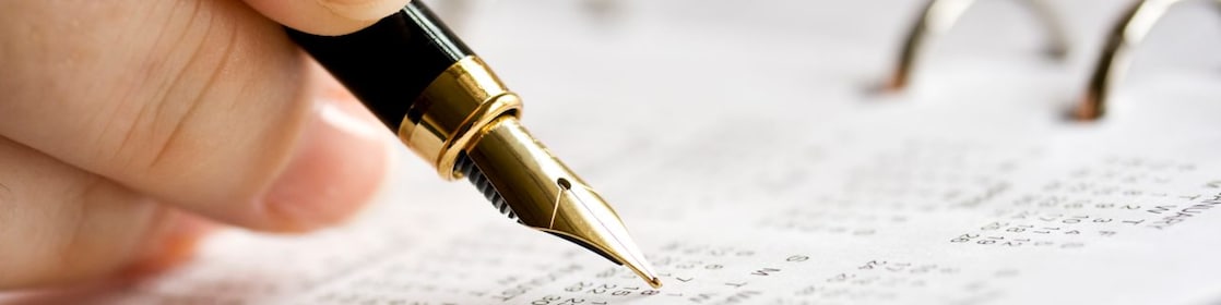 A man doing calculations on a calculator with printed charts on the desk