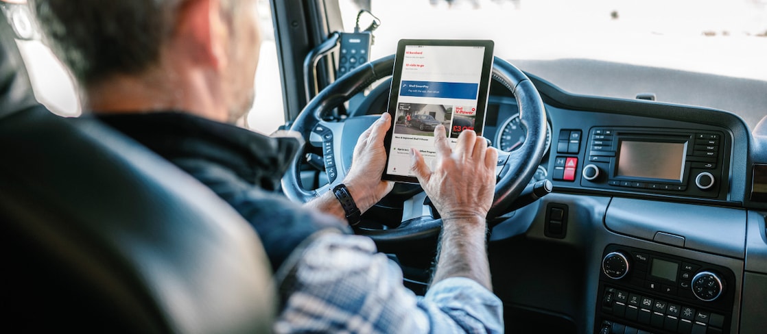 Mens aan het stuur van een vrachtwagen, met een tablet