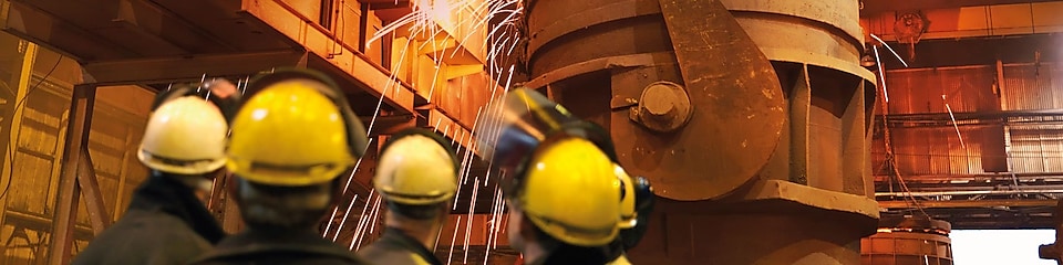 werknemers die kijken naar zwaar materieel in een metaalverwerkingsfabriek
