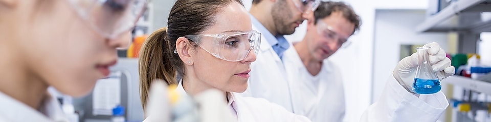 Wetenschappers in een laboratorium met witte laboratoriumjassen en veiligheidsbril zijn bezig met monsters