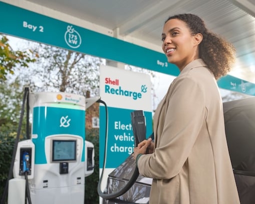 Vrouw bij een laadpaal van Shell Recharge