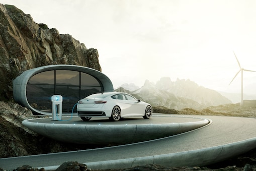 Witte elektrische auto in een Scandinavische omgeving met windturbines