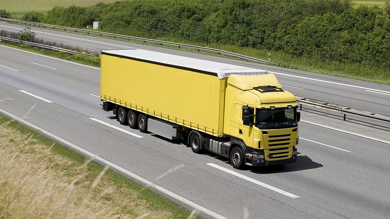 Blue sky over yellow truck on a highway