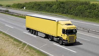 Blue sky over yellow truck on a highway