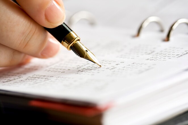 A man doing calculations on a calculator with printed charts on the desk