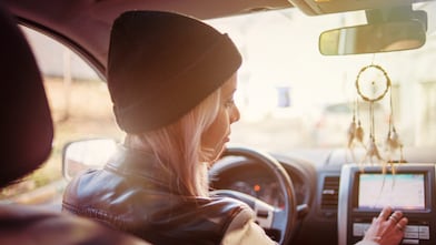 Een jonge vrouw leest de instructies op het navigatiesysteem van haar auto