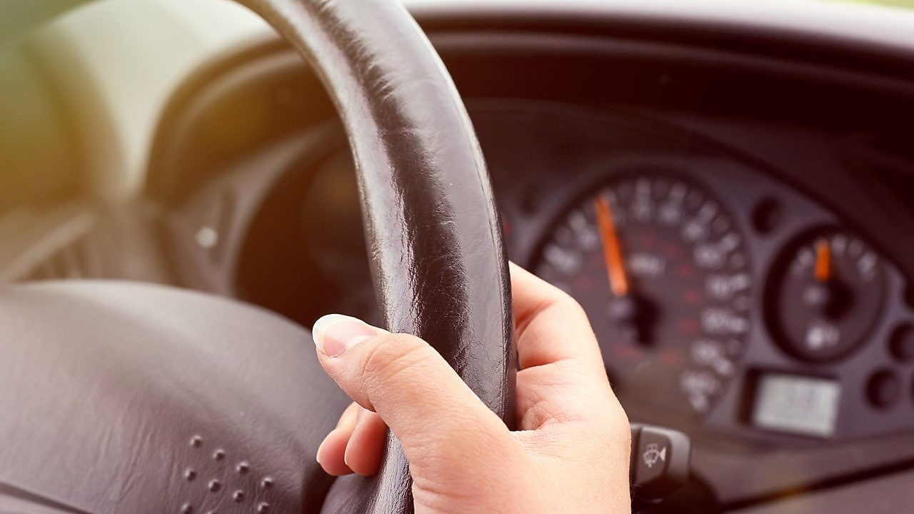 Handen die een stuurwiel vasthouden