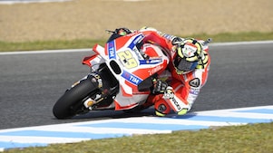 Ducati superbike en coureur snijden de bocht van een circuit aan