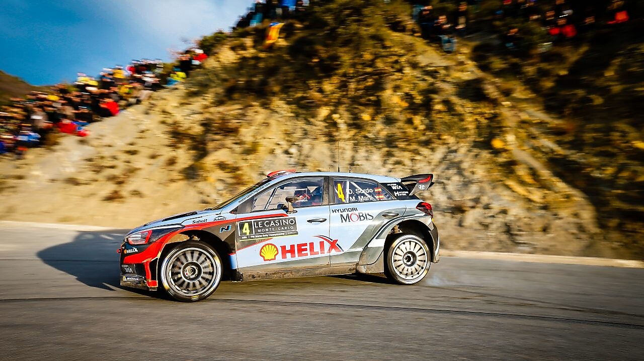Rally-auto rijdt rond een bocht in het wereldkampioenschap rally
