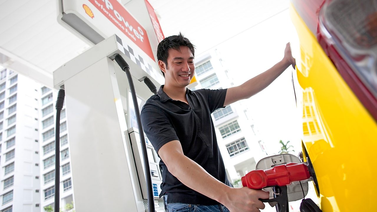Man tankt zijn auto aan een bezinepomp