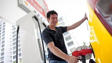 Man tankt zijn auto aan een bezinepomp