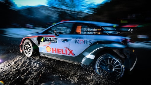 Rally-auto rijdt snel in het ochtendlicht in het wereldkampioenschap rally