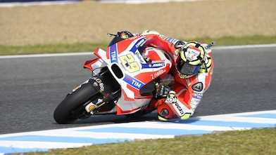 Ducati superbike en coureur snijden de bocht van een circuit aan